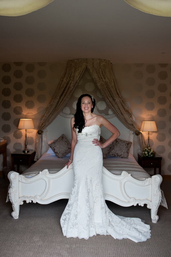 bride standing at end of bed