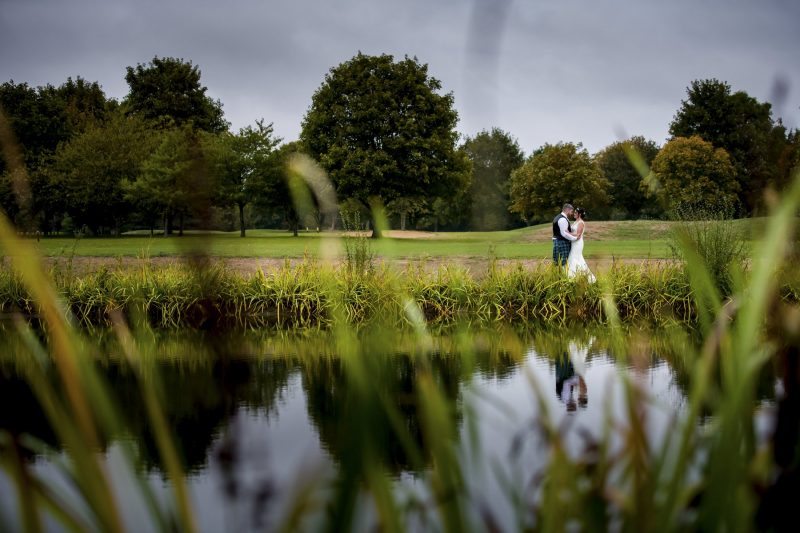 Wedding couple posing by lake