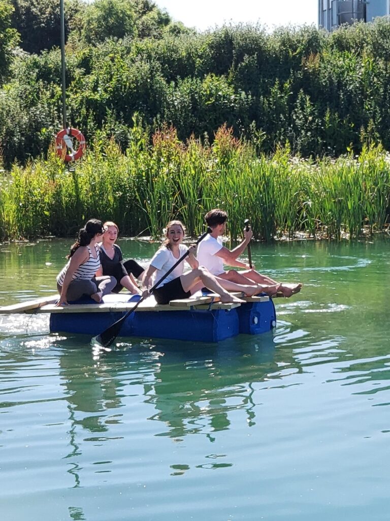 People on a team building raft on water