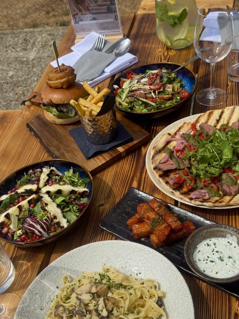 a selection of food including burgers, pasta, and salad in a bicester pub garden