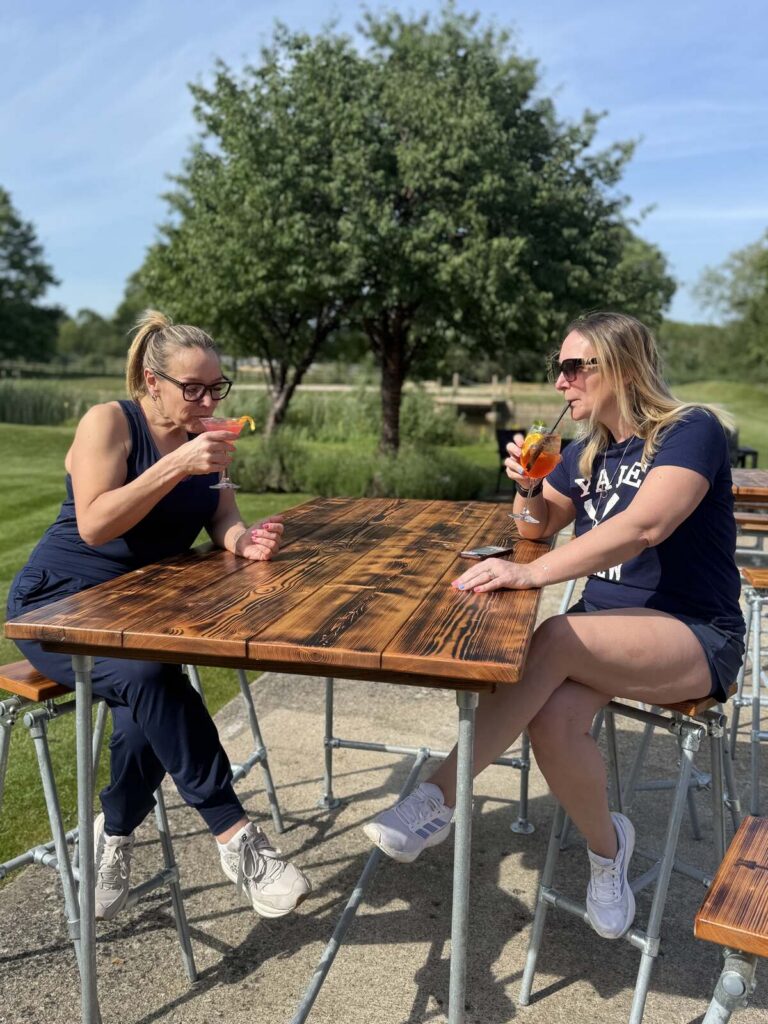 two women drinking cocktails in a pub garden in bicester